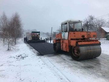 Асфальт на фоні снігу: у Солом'янському районі Києва спостерігали за роботою дорожників, які намагалися покращити проїжджу частину під час ожеледиці.